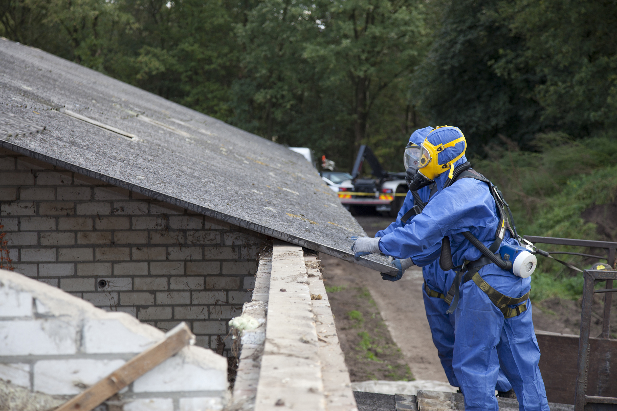 Certified technician conducting an asbestos survey on a roof