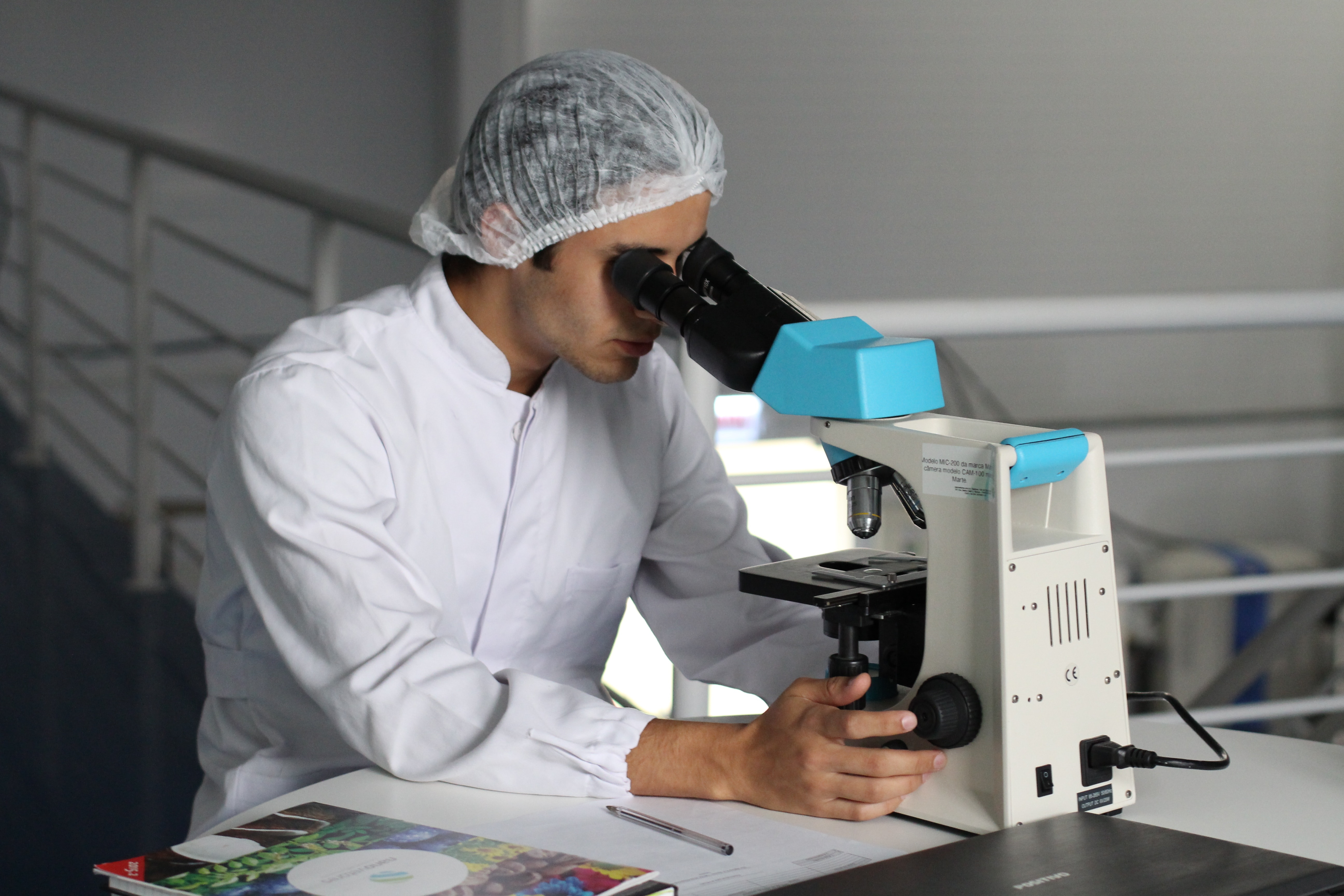 Technician analyzing a mold sample through a microscope